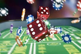 Dealer melempar dadu Sic Bo dalam wadah kaca transparan